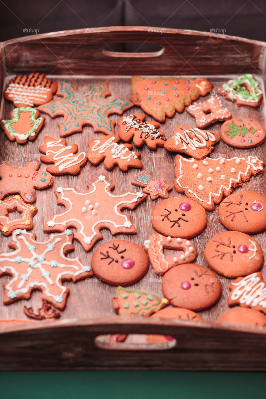 Christmas cookies decorated with frosting on wooden board