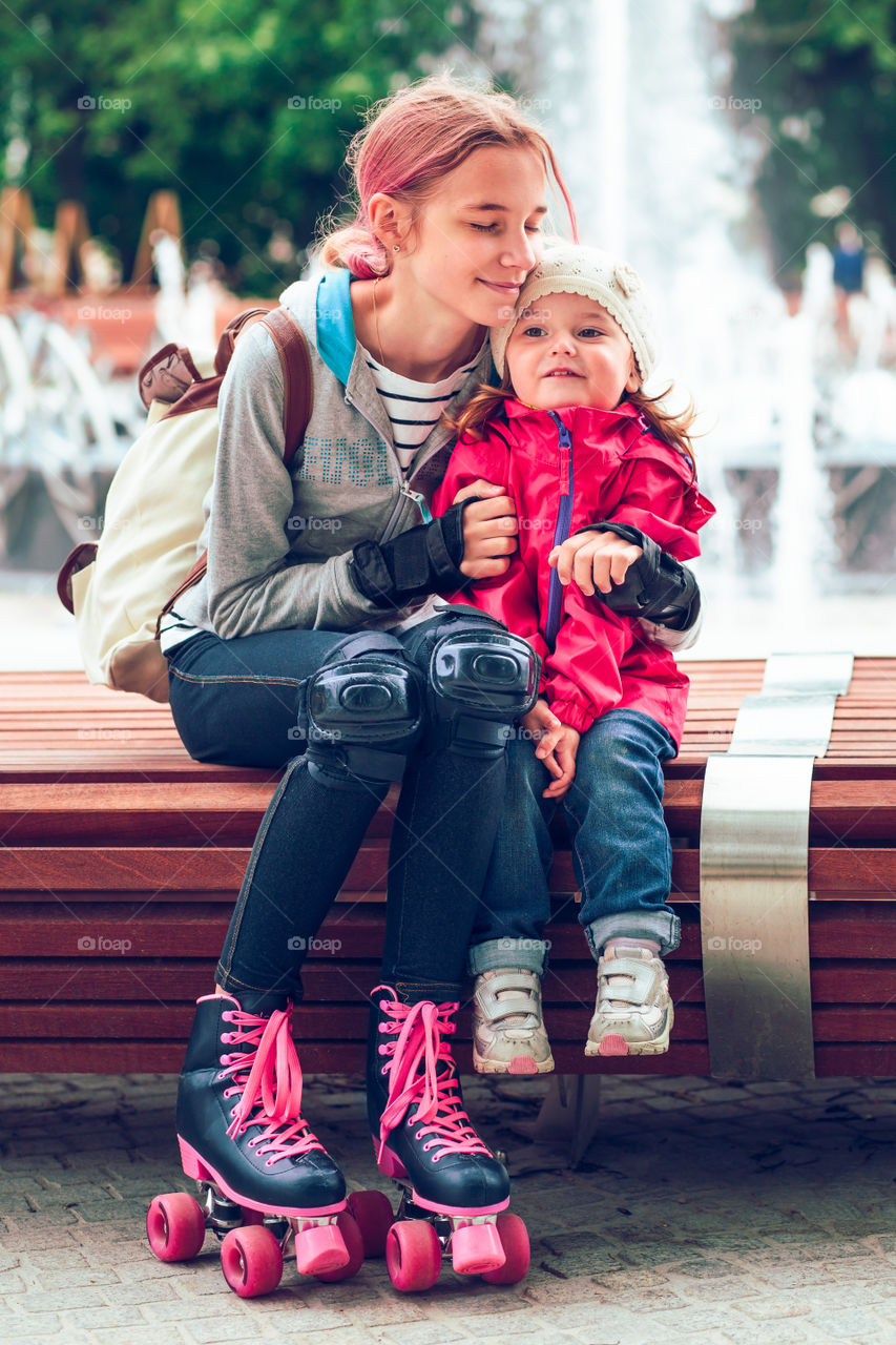 Mother and daughter sitting on wooden bench