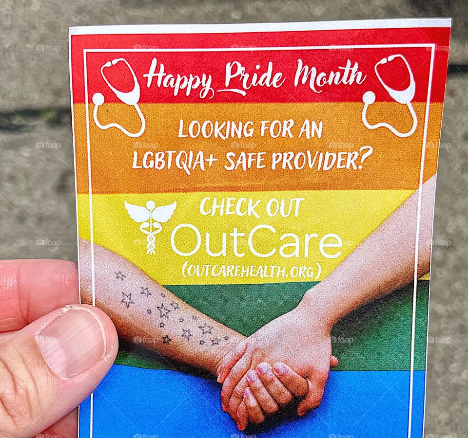 Handing out flyers at Pride event, handing out healthcare flyers at Pride, making a difference at Pride, helping the LGBTQ community, healthcare for all, pride colors on a flyer