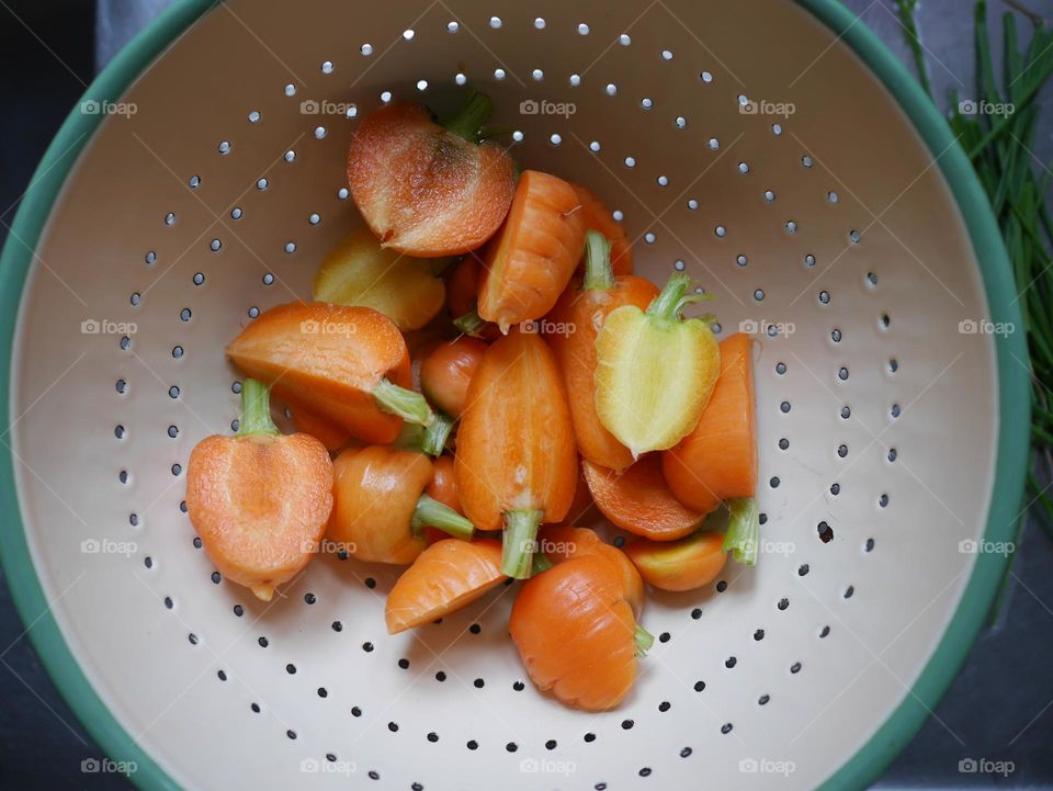 Carrot cuts being cooked and drained 