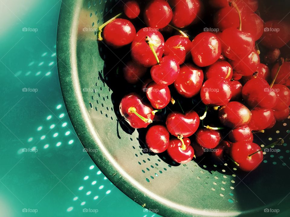 Elevated view of cherries in colander