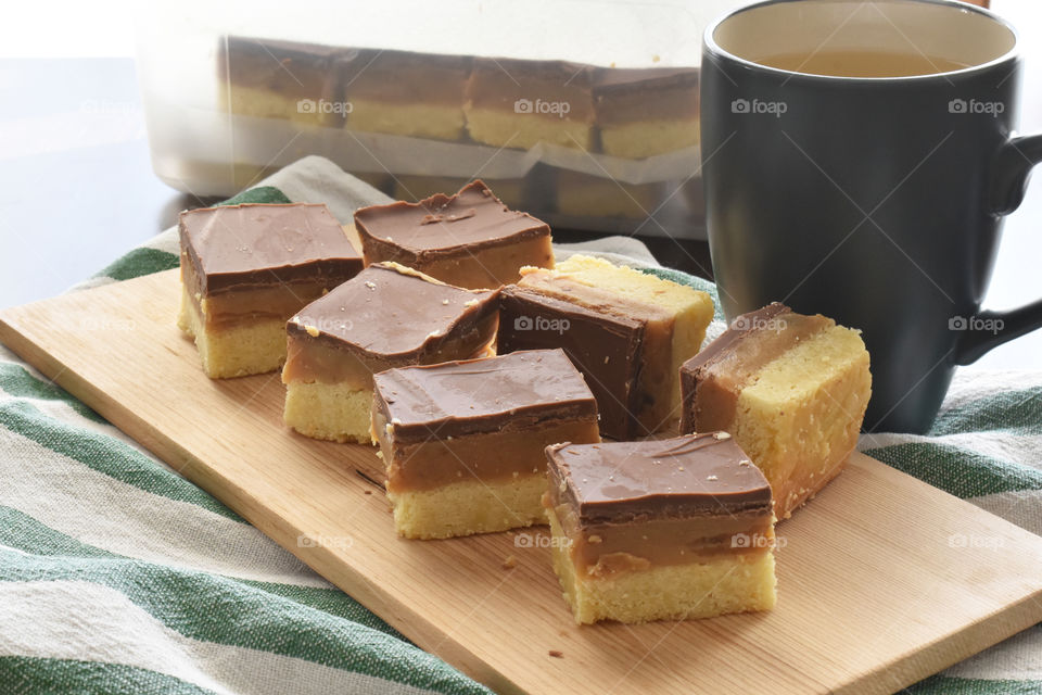 Millionaire's shortbread, caramel shortcake, or millionaire's slice on a chopping board.