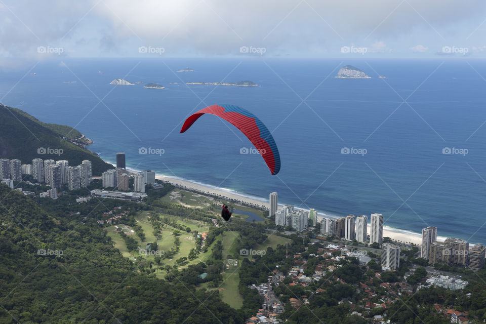 Paraglider flying over Sao Conrrado in Rio de Janeiro Brazil.