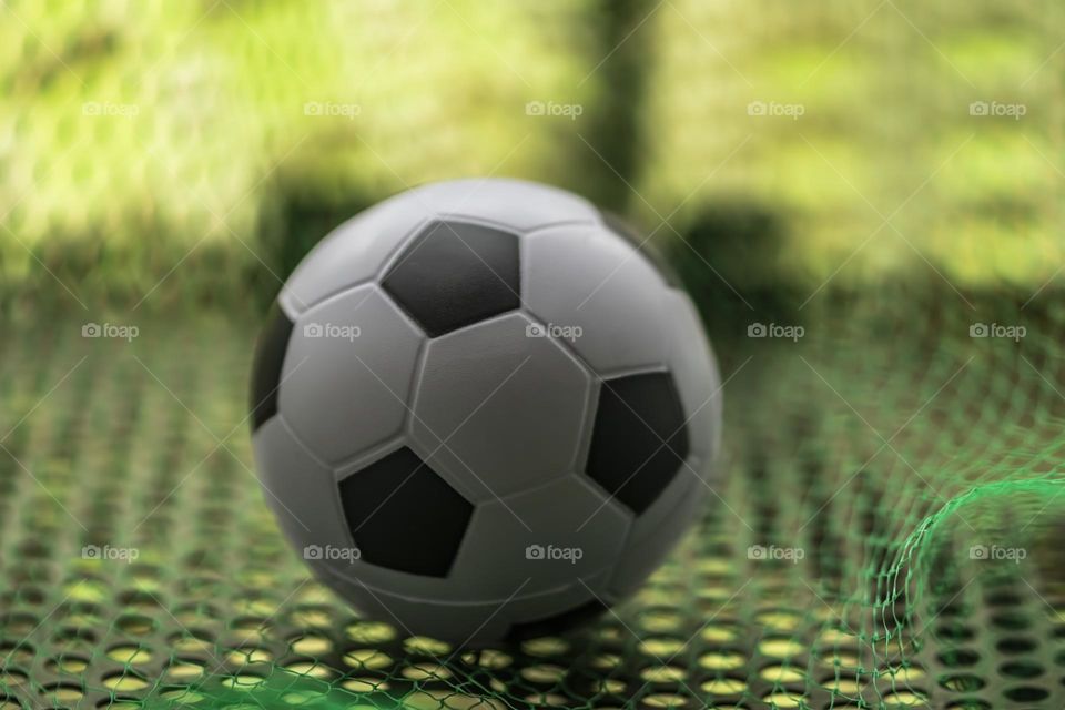 Soccer ball and Green net on soccer field stadium background