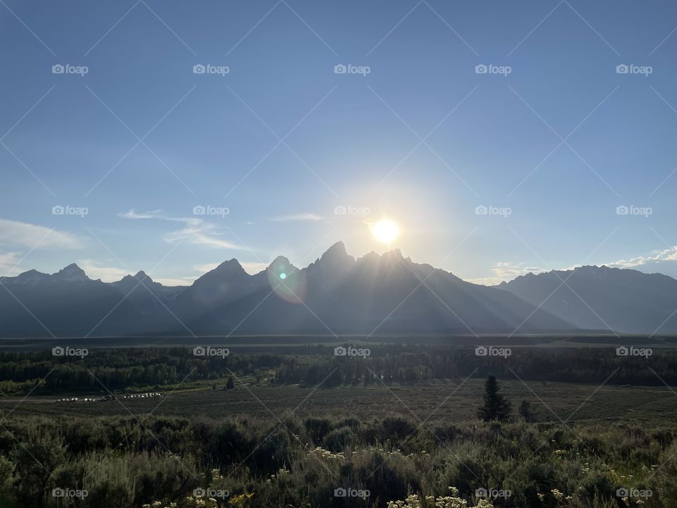 Sunsetting sunset sun over mountain mountains view scenic land prairie landscape fields bushes sky blue clouds sunrise