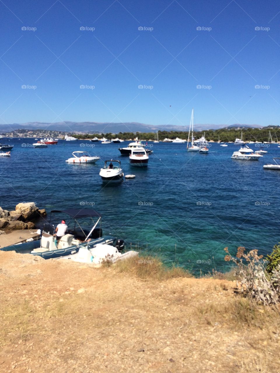Beautiful azur sea with boats and mountain