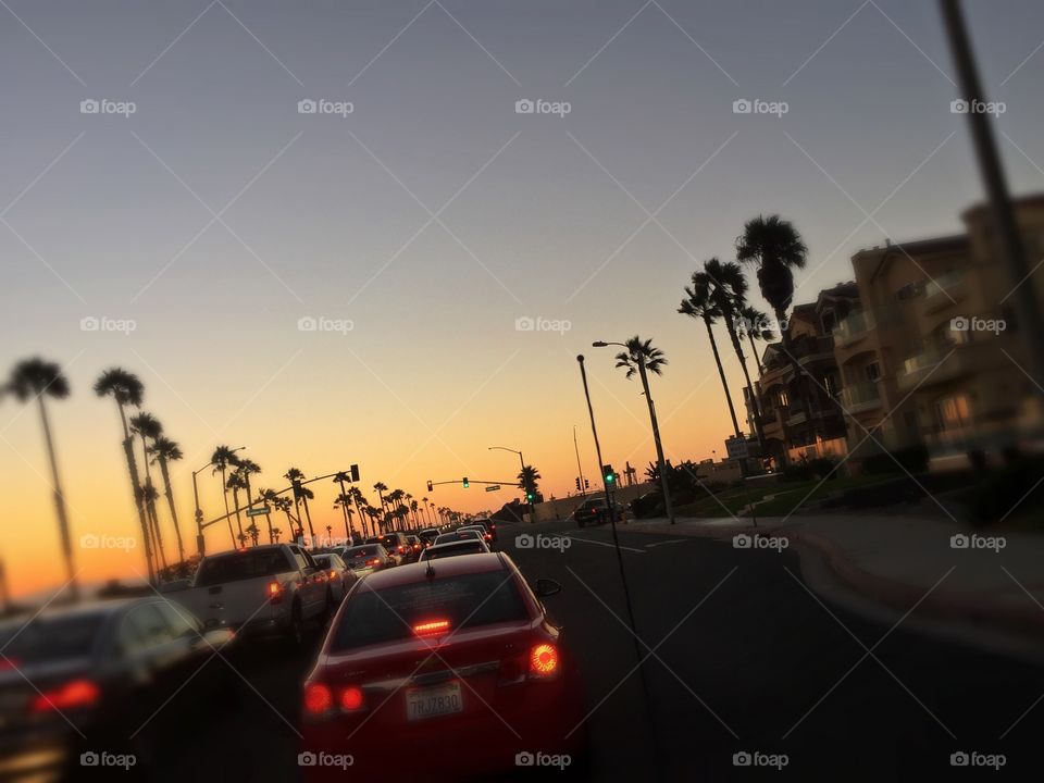 Driving along Pacific Coast Highway in Huntington Beach, CA while enjoying be sunset.