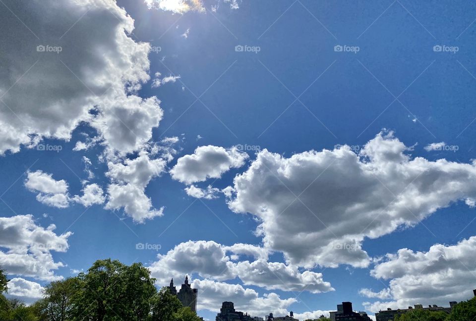 Lovely clouds in a sunny day. Blue sky, sun rays, hanging clouds, good weather. 