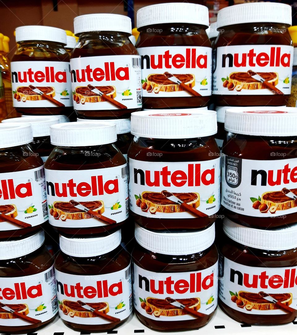 A Nutella jar sitting on a kitchen counter in Casablanca on January 1, 2025. The jar is partially open, revealing the creamy, rich hazelnut spread inside, surrounded by soft kitchen lighting that highlights its texture.