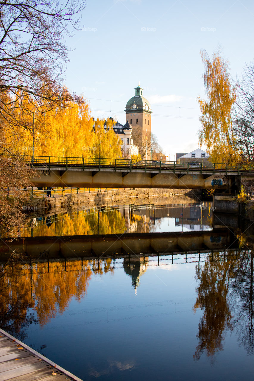 urban reflections onto the still November River in central Borås Sweden