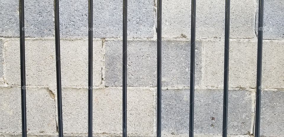 Cinder Block Brick Wall with Gated Bars in Foreground