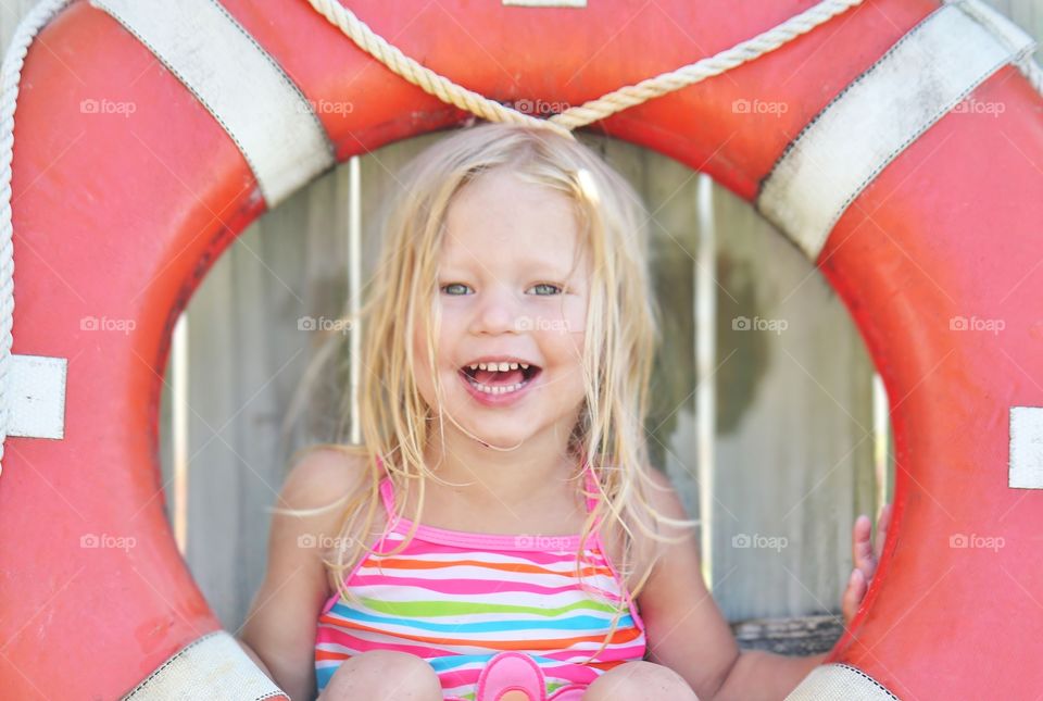 Little girl playing with a life preserver