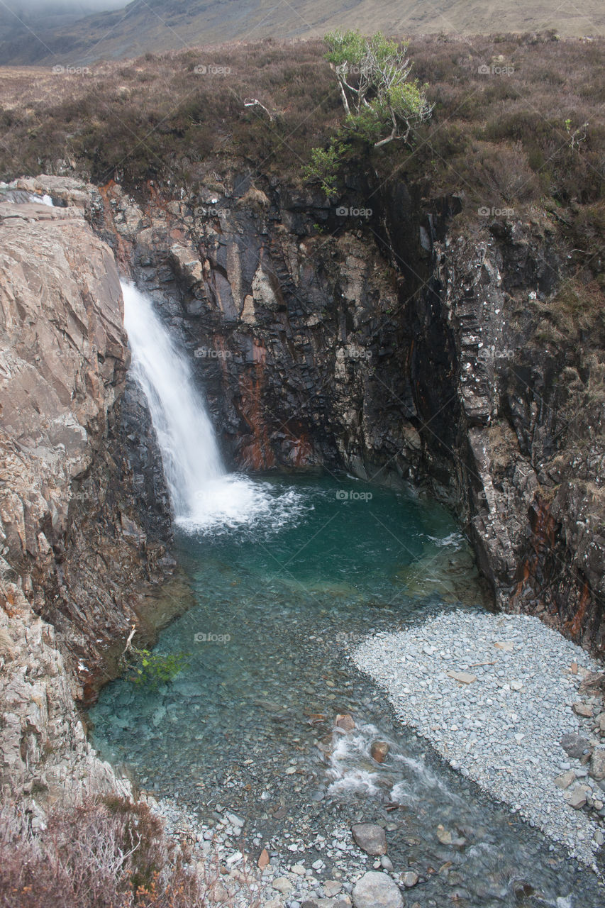 A waterfall washes into the blue water of the Fairy Pools on the Isle of Skye - no edits, #nofilter, true nature, #truephotos