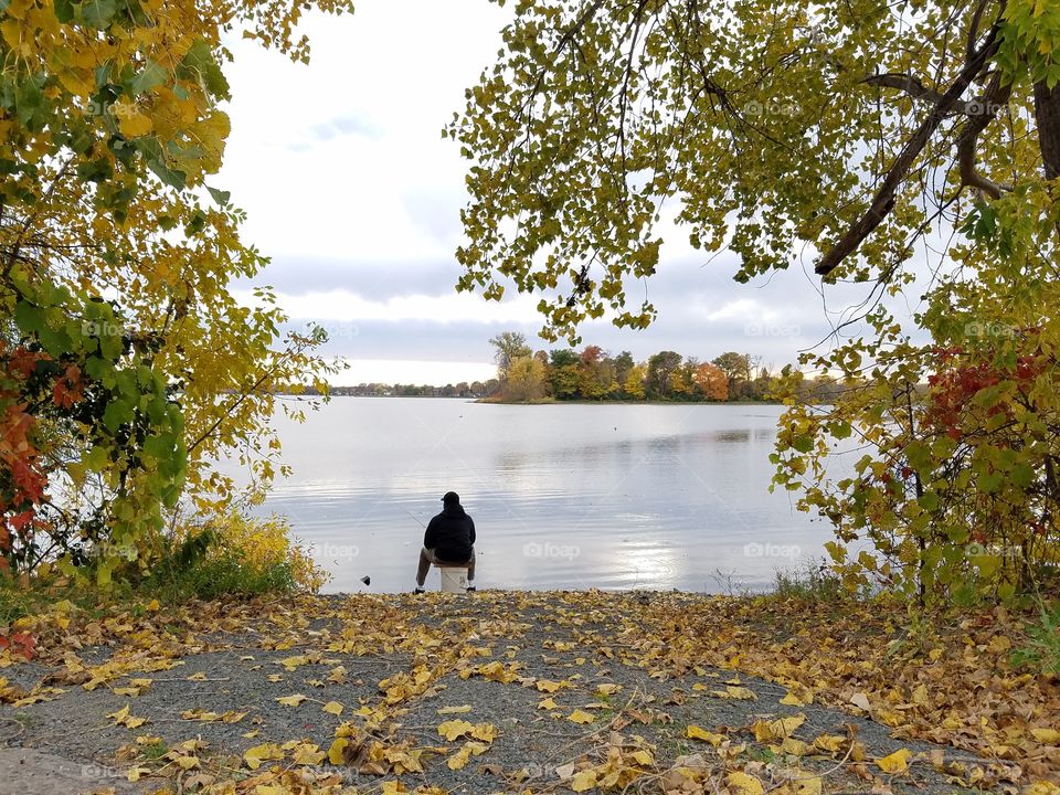 man fishing lakeside in fall