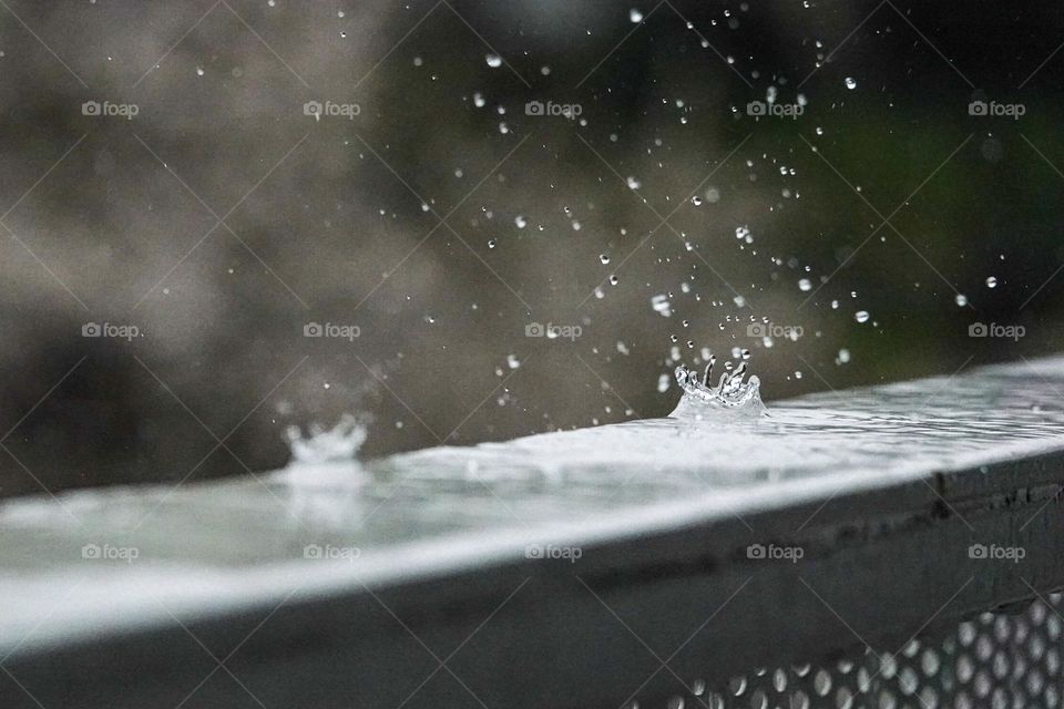 A raindrop splashes on a cold steel rail