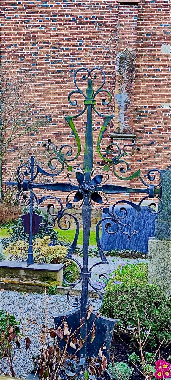 This beautiful cast iron ornamented cross adorns one of the graves at the cemetery of “Ortenburg” in “Bavaria”, Germany. 2024. Hypnotic Productions