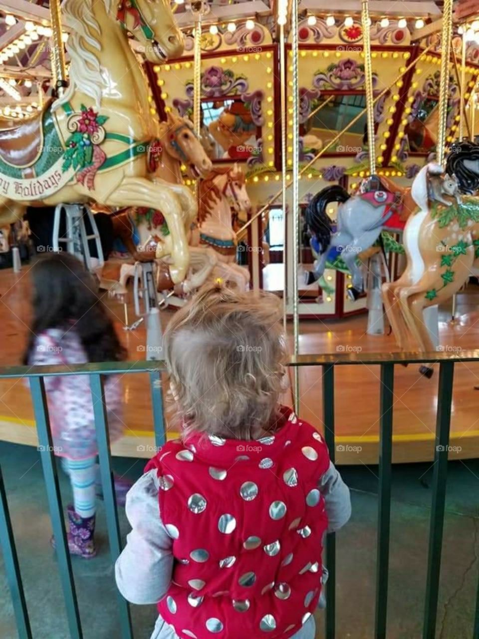 Girl watches carousel