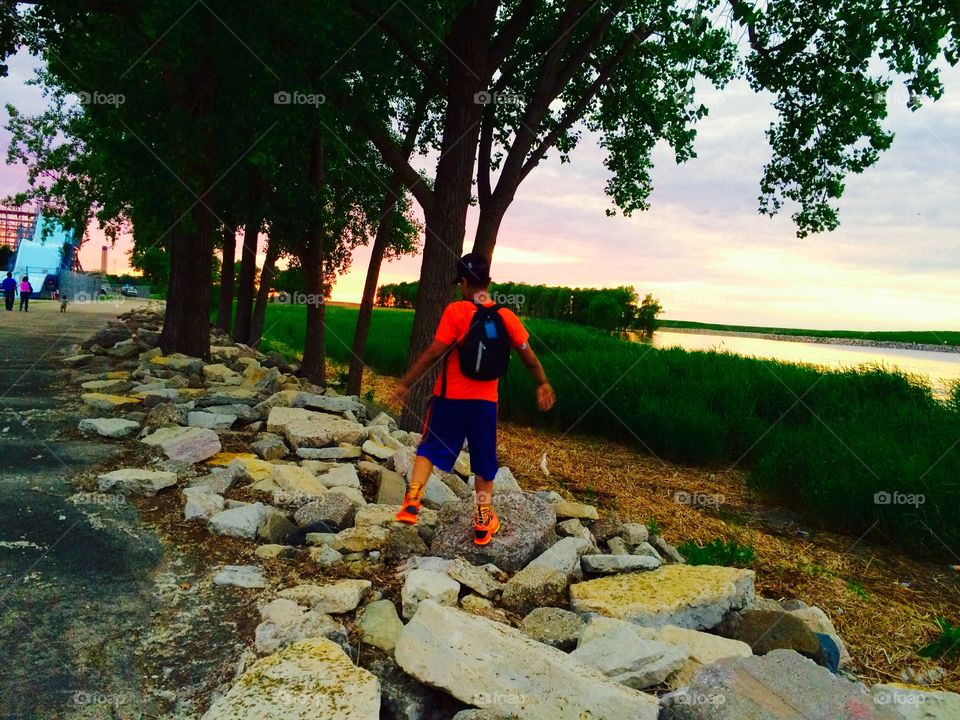 Child playing on the rocks . A few minutes before sunset 