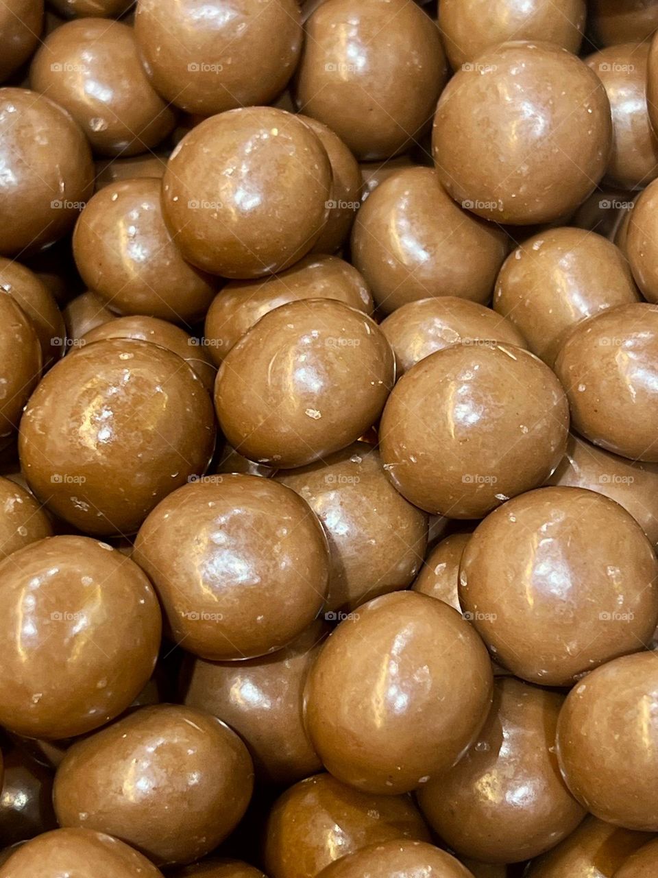 Close-up of a brown, round chocolate dragee