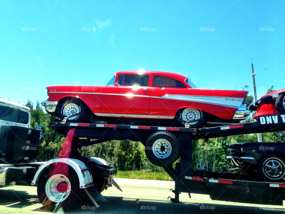 Classic car on tow truck in highway