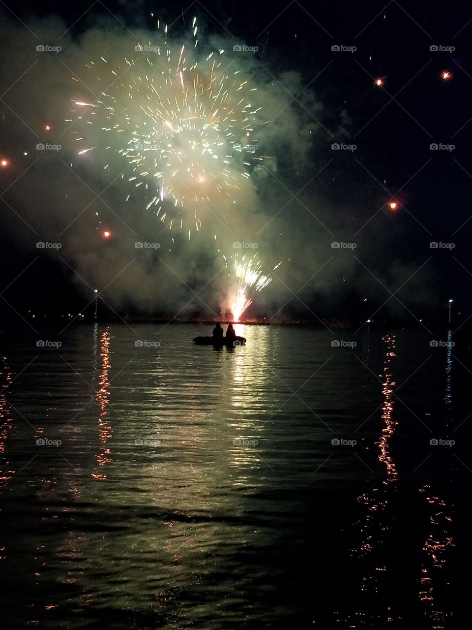 lovers watch the fireworks from a canoe on the lake