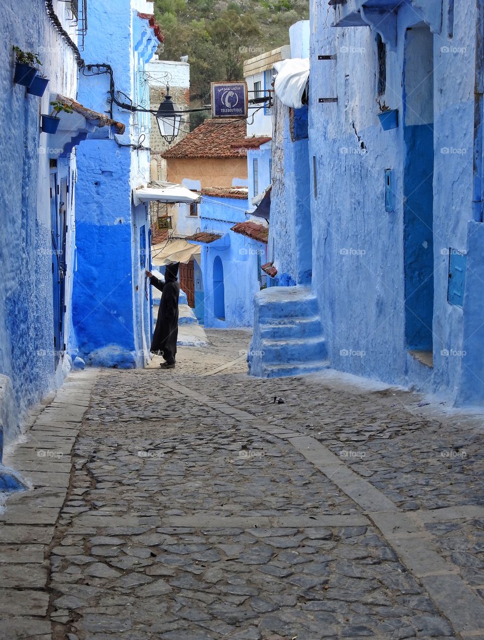 Man in traditional robe in blue alley