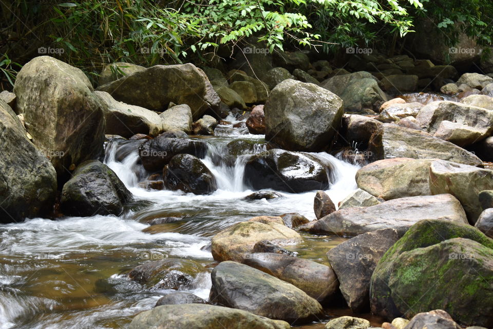 water flowing through stones in greenish background