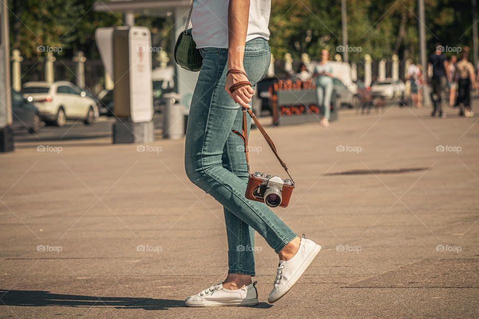 Girl walks in the city with a vintage camera
