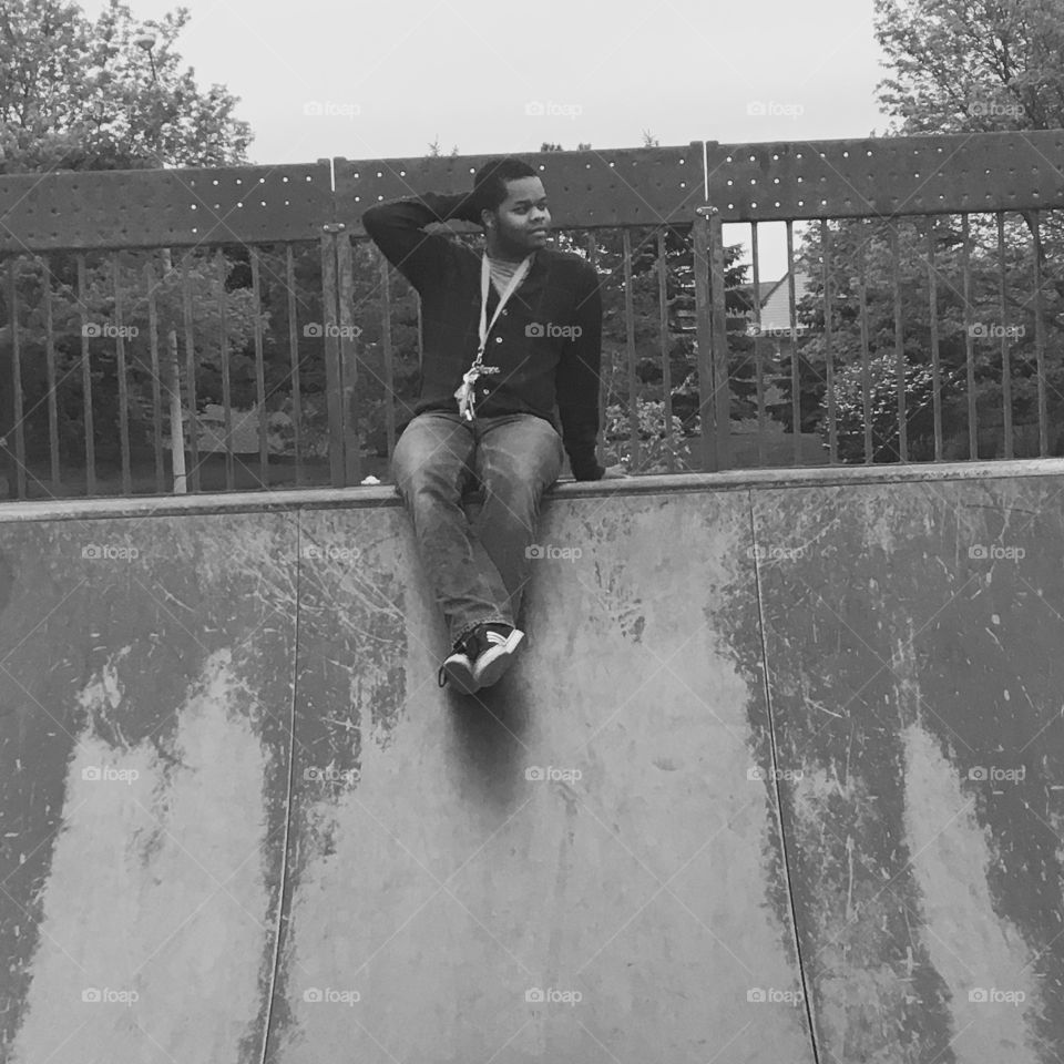 African man sitting on wall