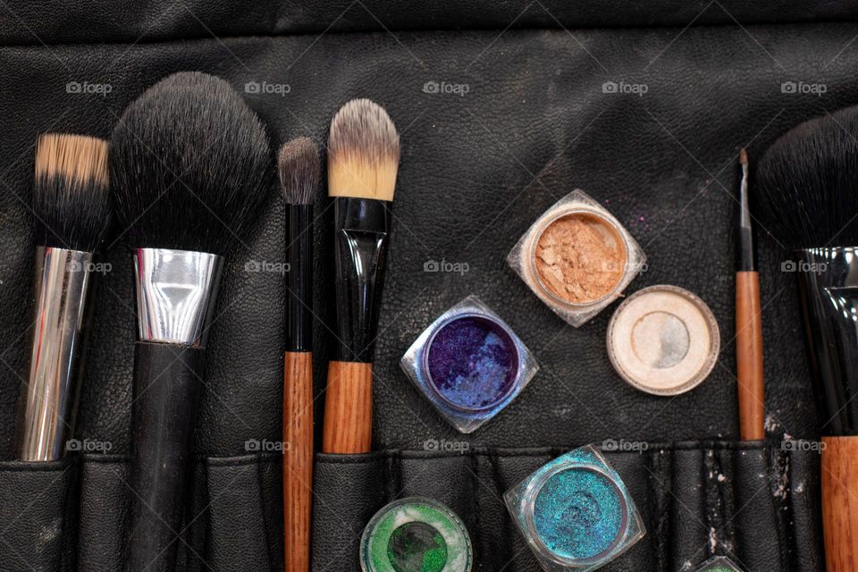 Set for professional make-up.  Brushes, shadows, glitter and mascara close up. Beautician job. Beauty salon