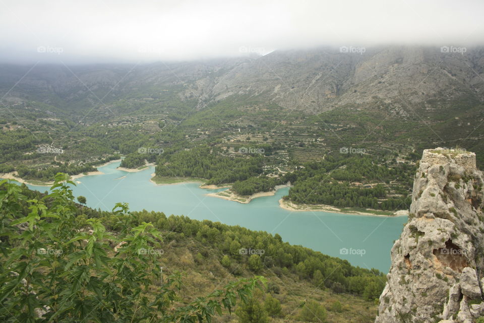 I have climbed on top of a mountain to be able to take out this beautiful landscape. You can see mountains, a river and a lot of vegetation.