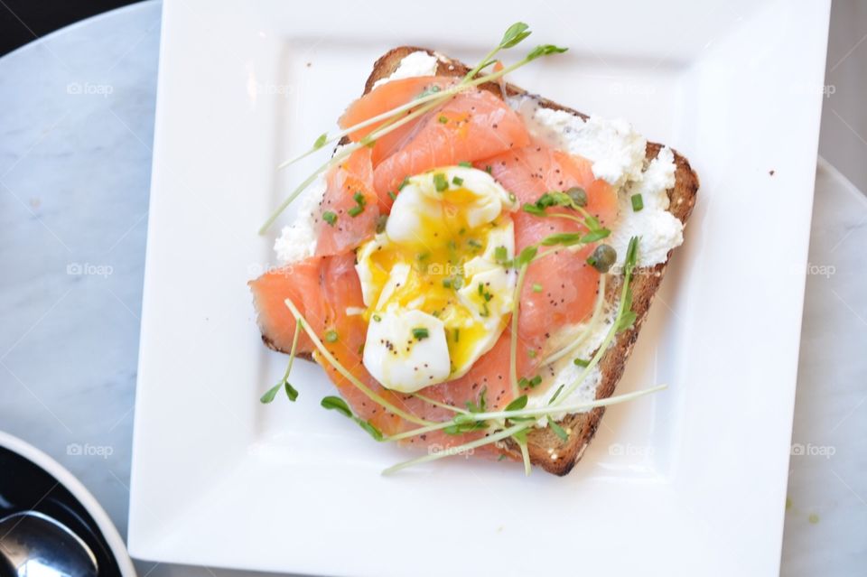 Ricotta, smoked salmon, and poached egg toast. Toast topped with ricotta, smoked salmon and a poached egg