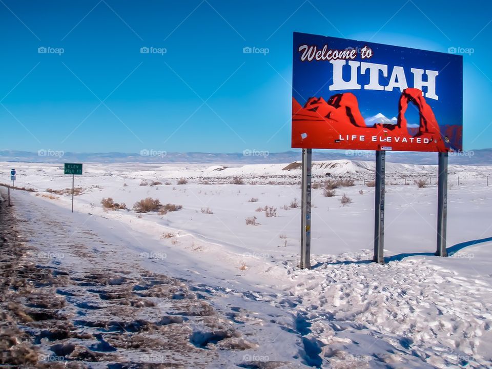 Snow desert boarder sign welcome to Utah 