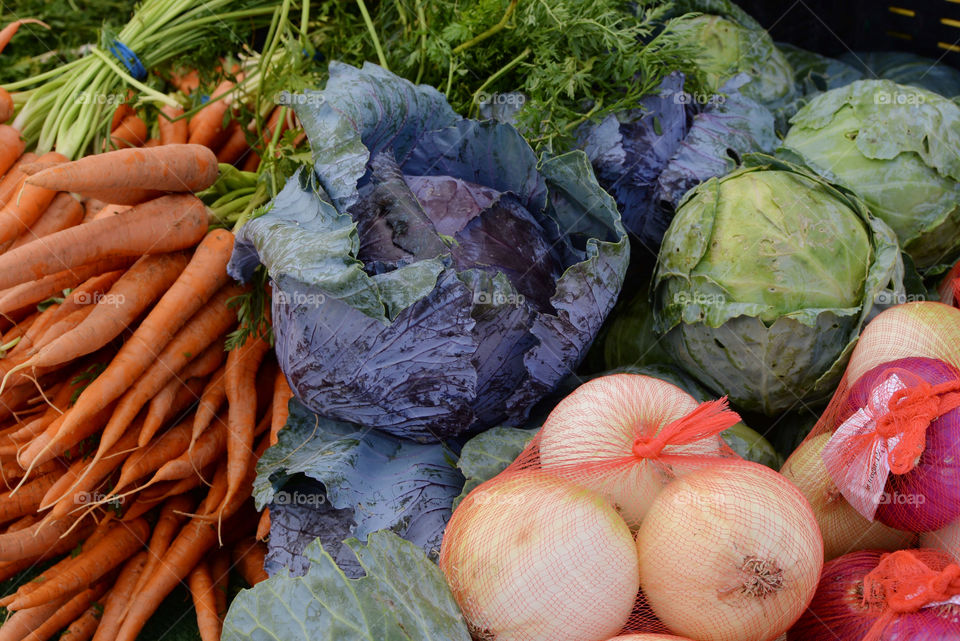 Fresh carrots,purple cabbage and onions at a farmers market 