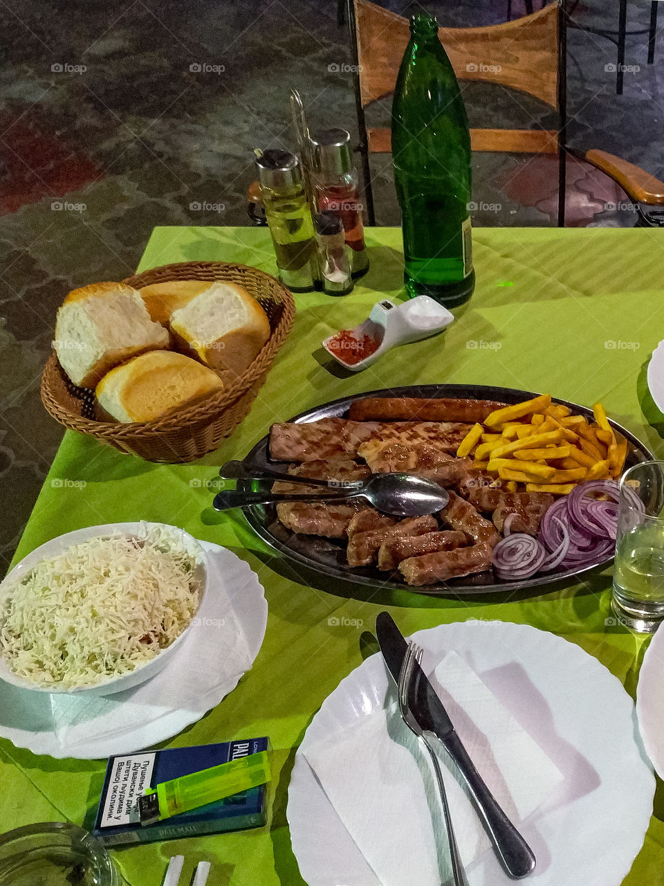 Mixed barbecue meat, salad, bread, franch fries, and plates