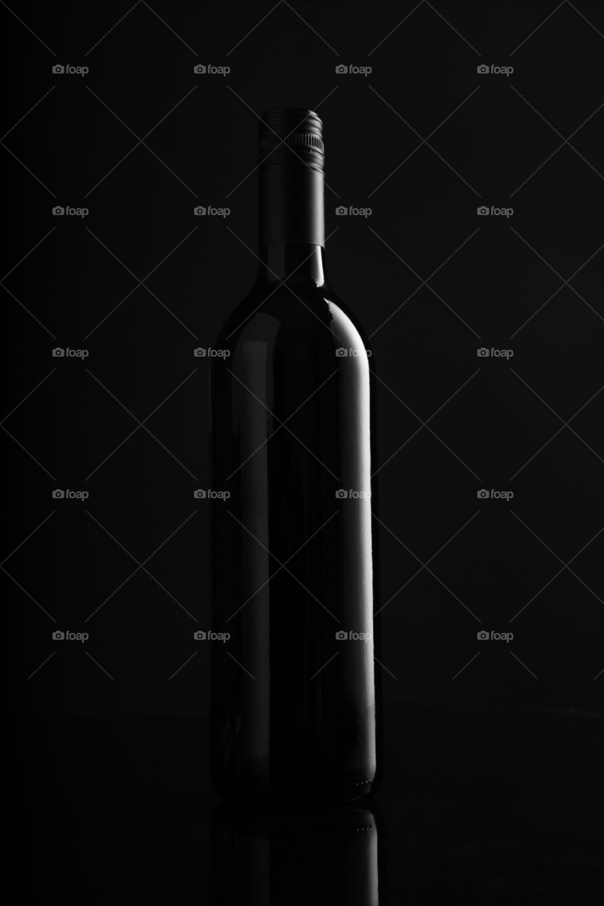 Abstract red wine bottle with black background