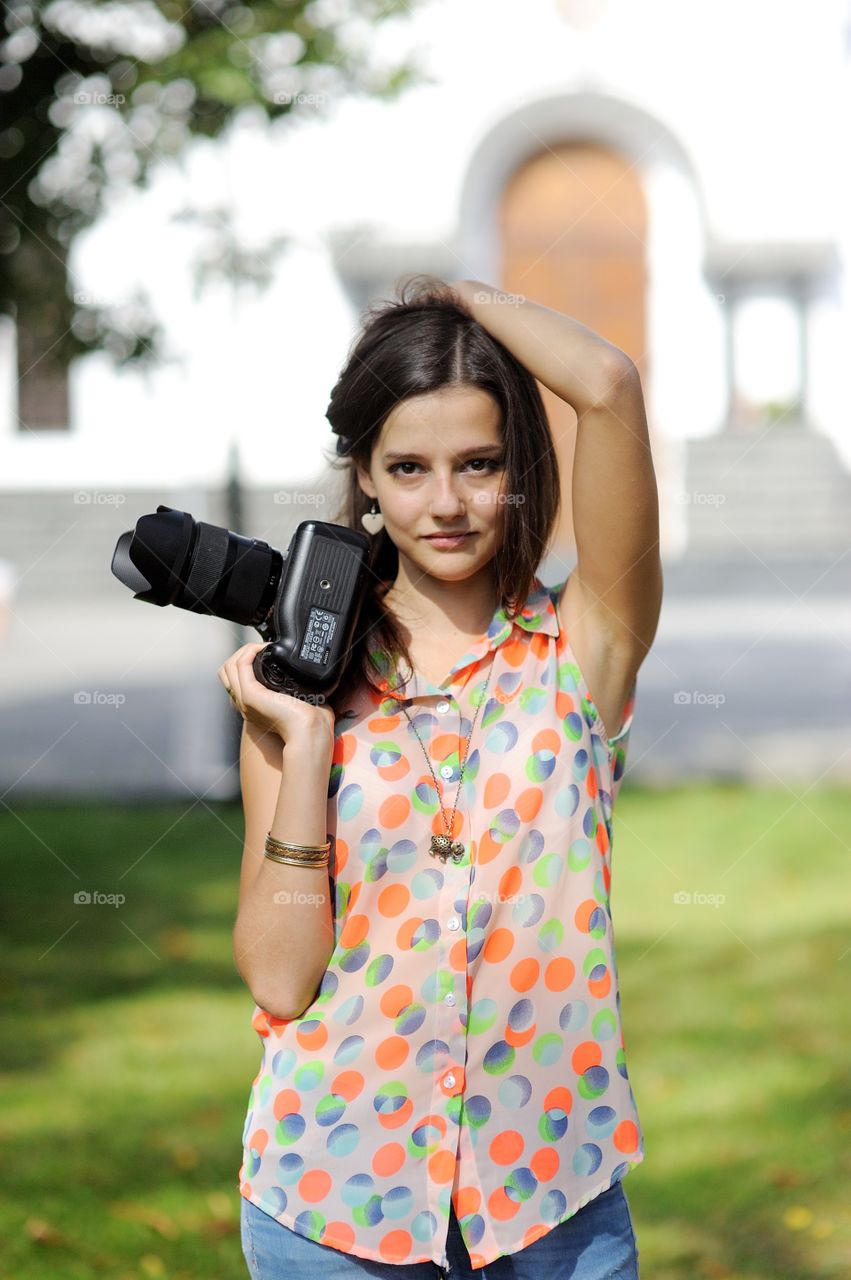 Portrait of a young woman holding camera