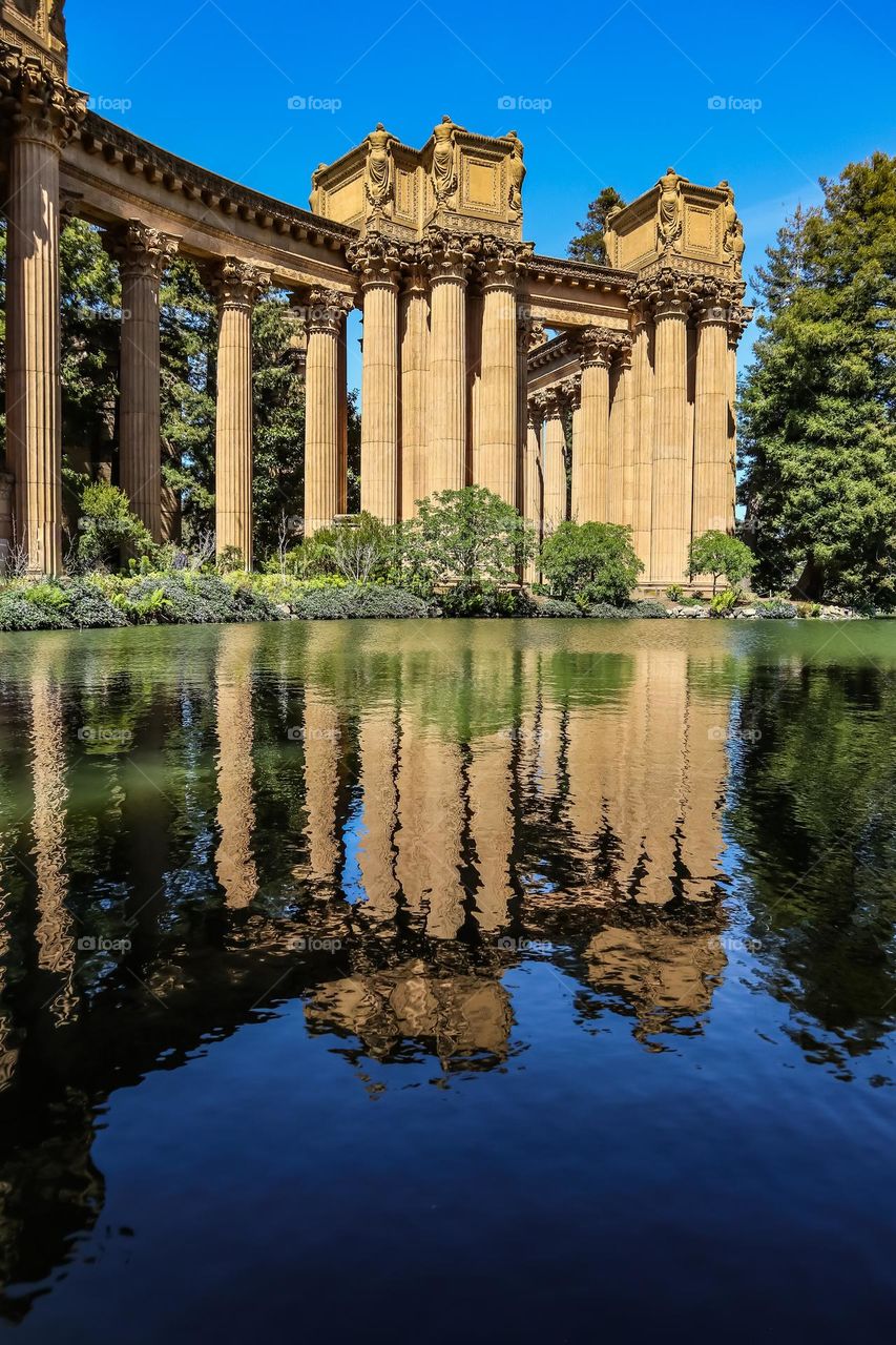 Promenade of the palace of fine arts in San Francisco California reflecting on the calm lagoon on a clear beautiful day in the city