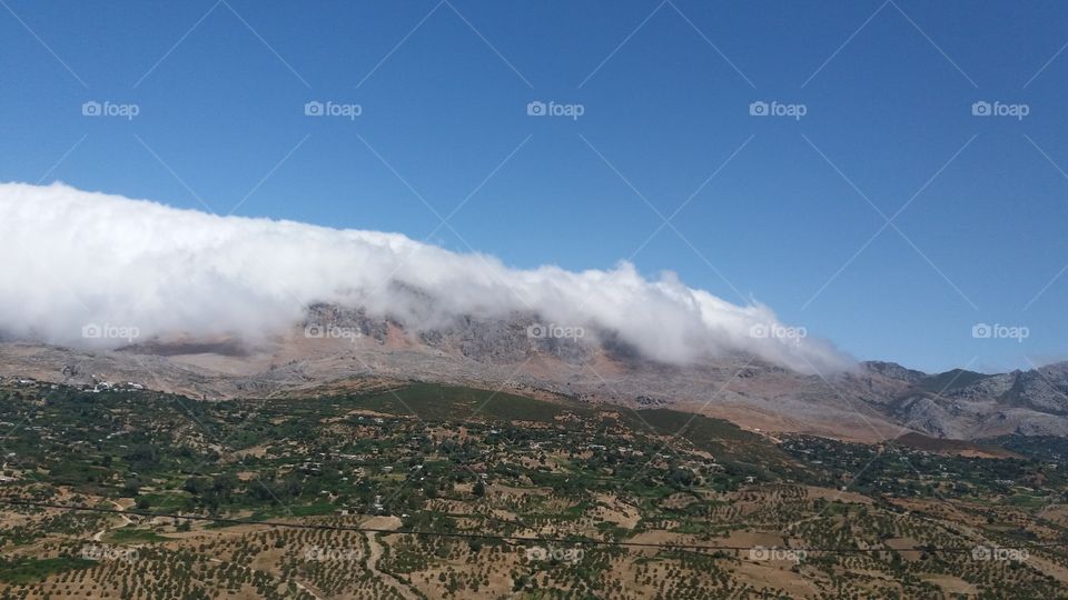 A view of a mountain covered with clouds