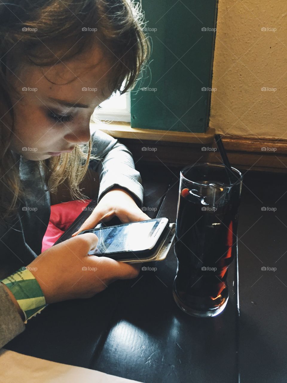 Girl using her phone in the restaurant