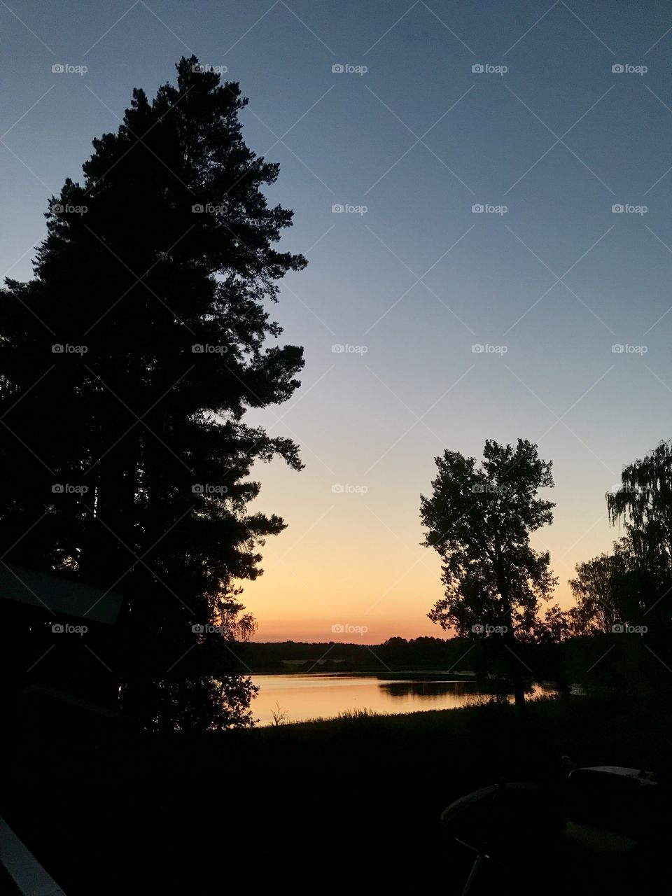 Sunset over a lake with Silhouette of forest trees