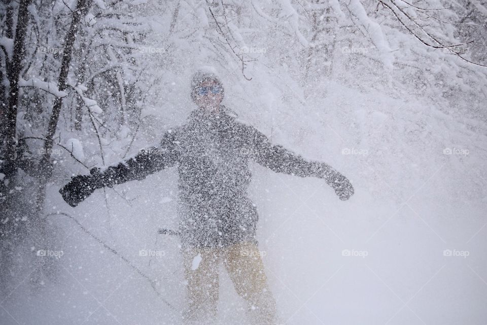 A young man covered in blizzard weather, snow everywhere