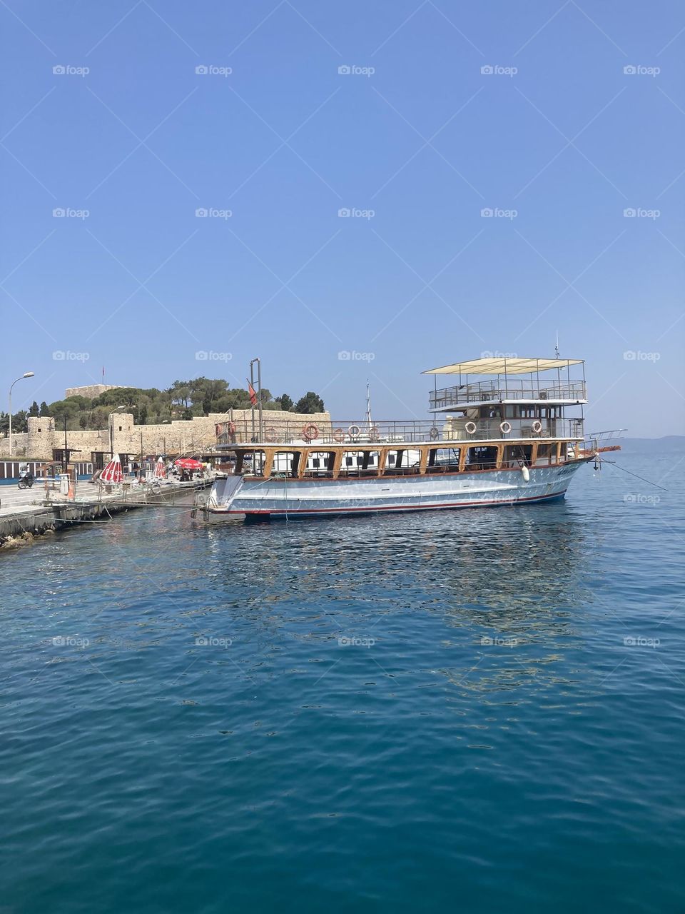 Sunny holidays I’m Turkey. Walk in the cute city and charming streets by the beach in Kusadasi. perfect blue sky and ocean view. Beach and the shore. To travel is to live. Gorgeous tall palm trees.