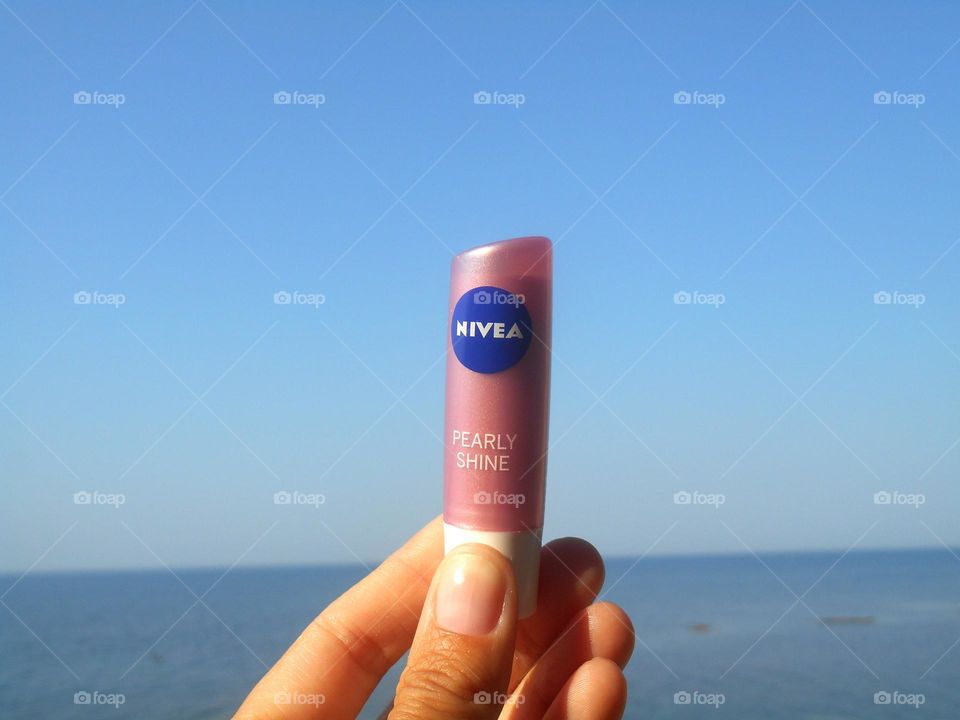 lipstick in the hand blue sky and sea background,Nivea product love, summer time