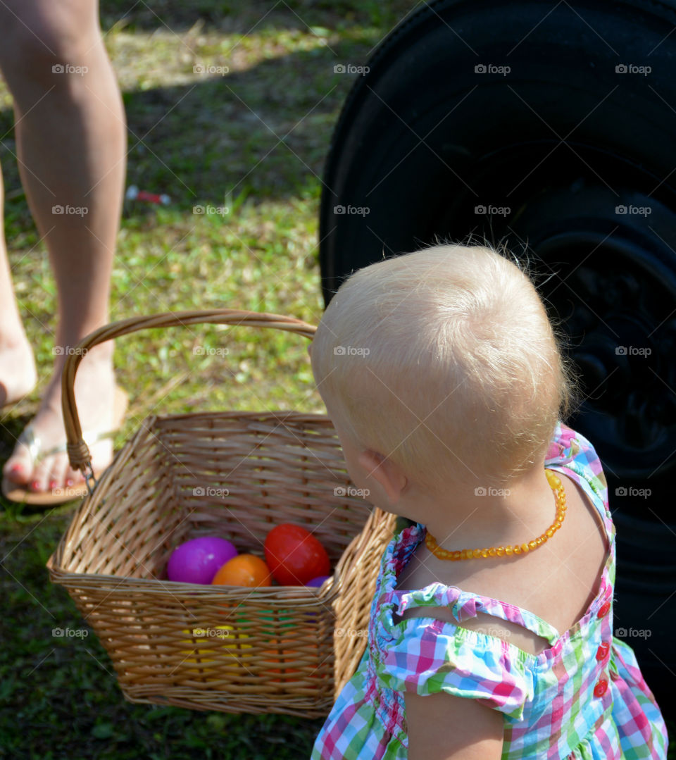 Girl with blonde hair and basket with toys