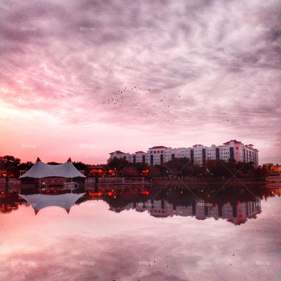 A morning sunrise over the lake and surrounding buildings at Cranes Roost Park in Altamonte Springs, Florida.