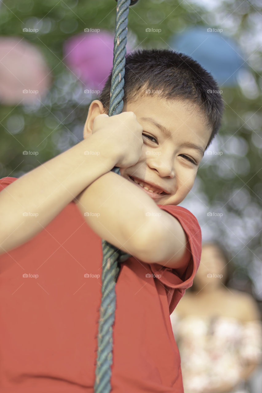 Asean boy at the nodes the rope and smiling happily.