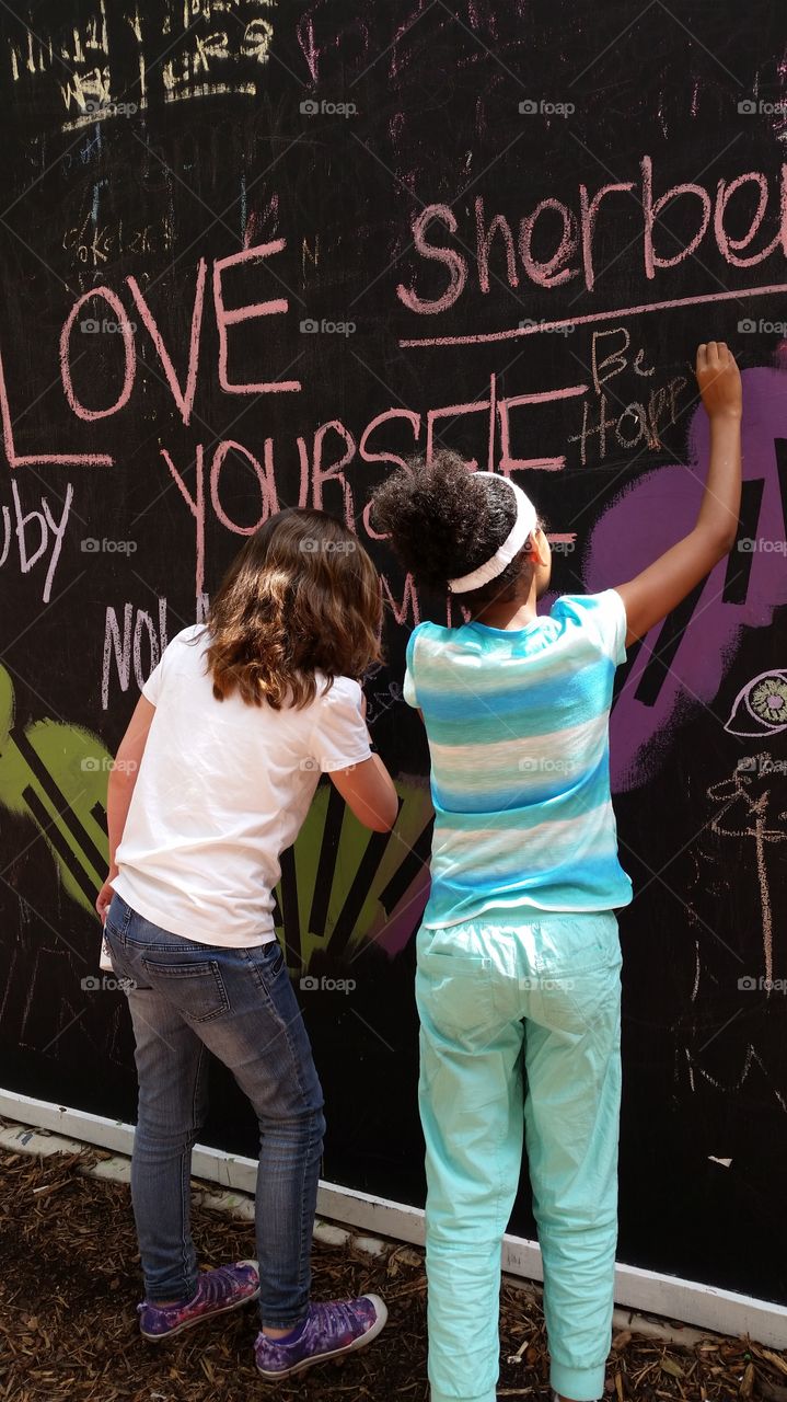 chalk wall. Kids write on a huge chalk wall downtown Dallas