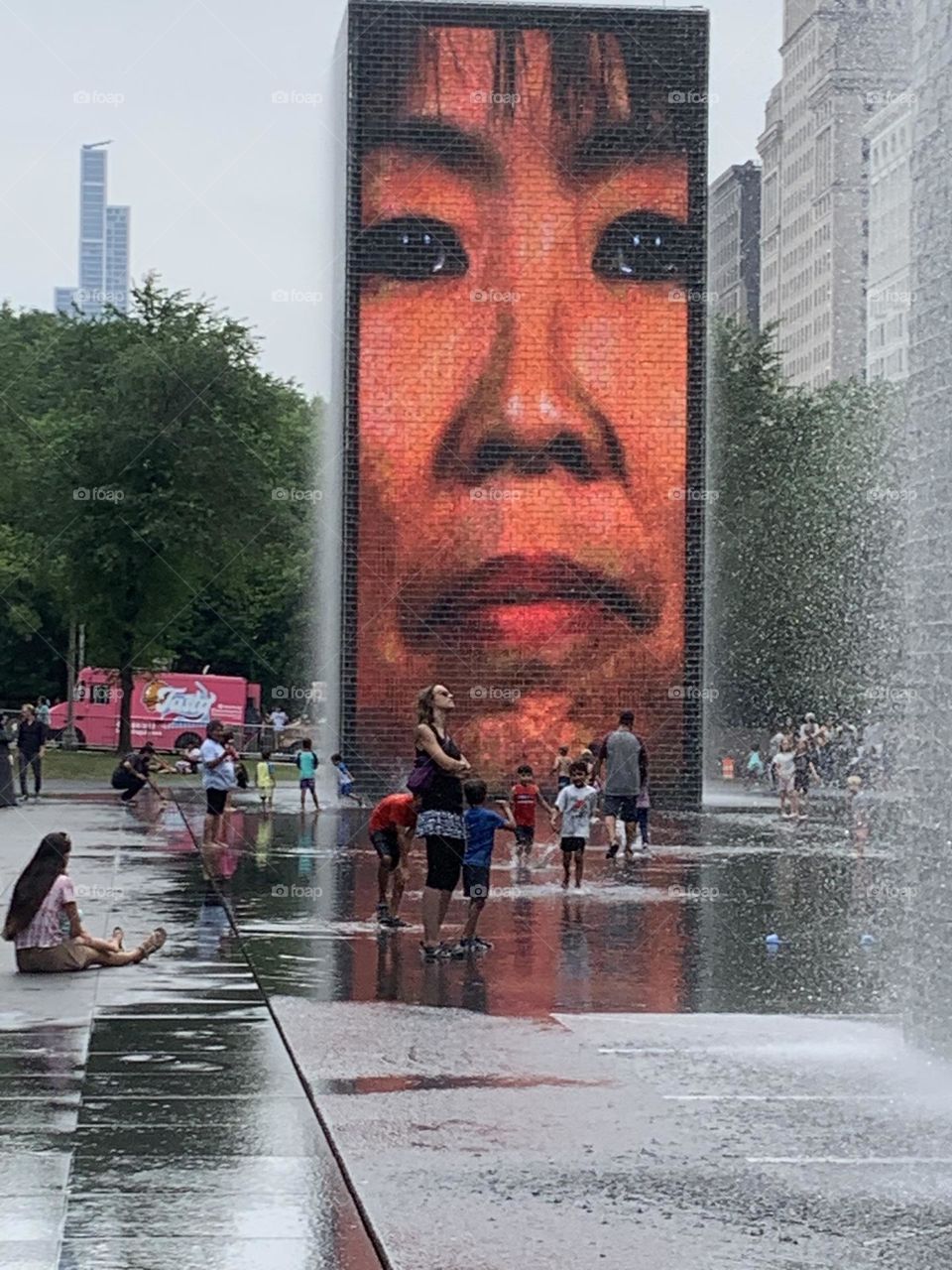 Children playing in Crown Fountain on a hot July day In Millennium Park, Chicago.