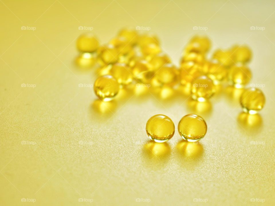 vitamins capsules oils round beautiful texture yellow background